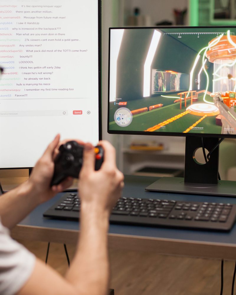 Concentrated young man using joystick while playing online shooter games.